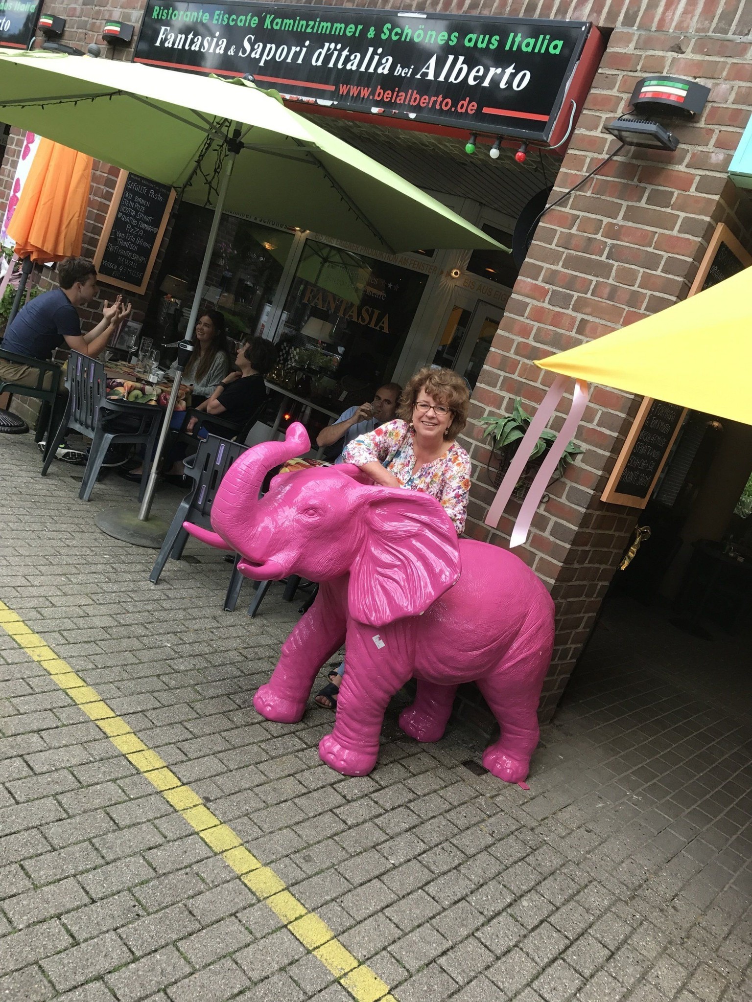 Bei Alberto — Außenansicht mit rosa Elefant und Außengastronomie